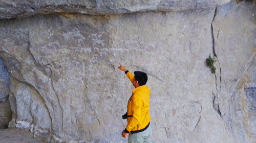 Persona señalando pinturas en Cueva de Sumbay